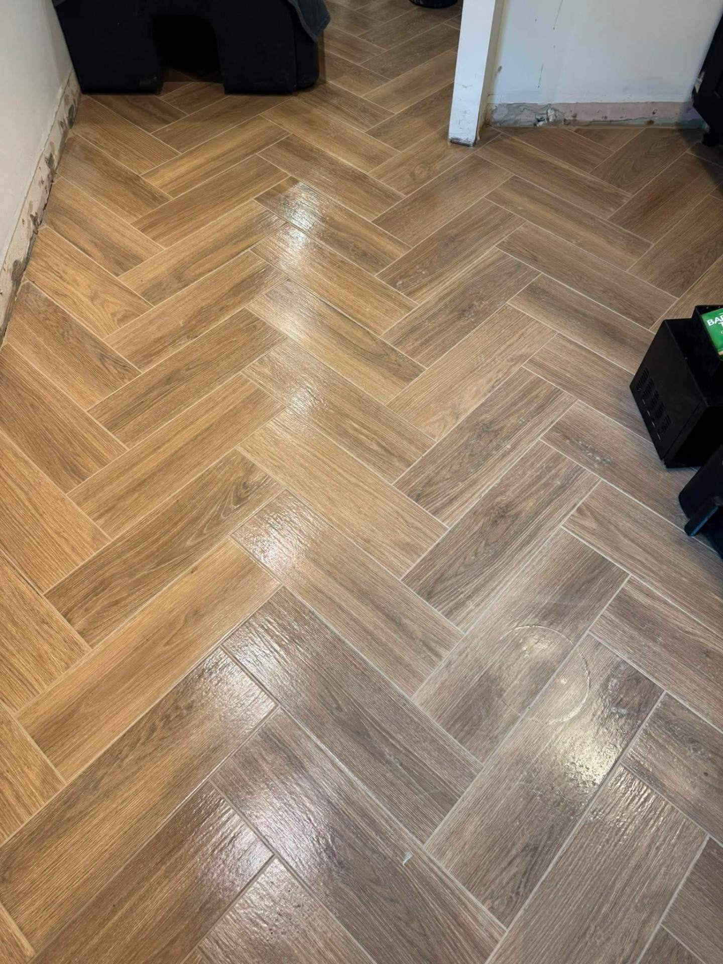 Herringbone wood-effect porcelain floor through to next room