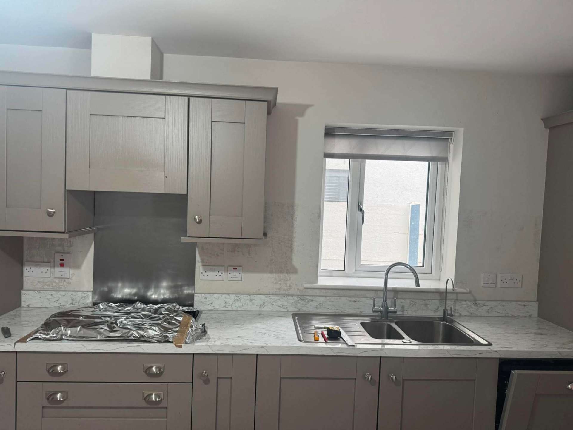 Grey shaker kitchen with Calacatta marble splashback, finished