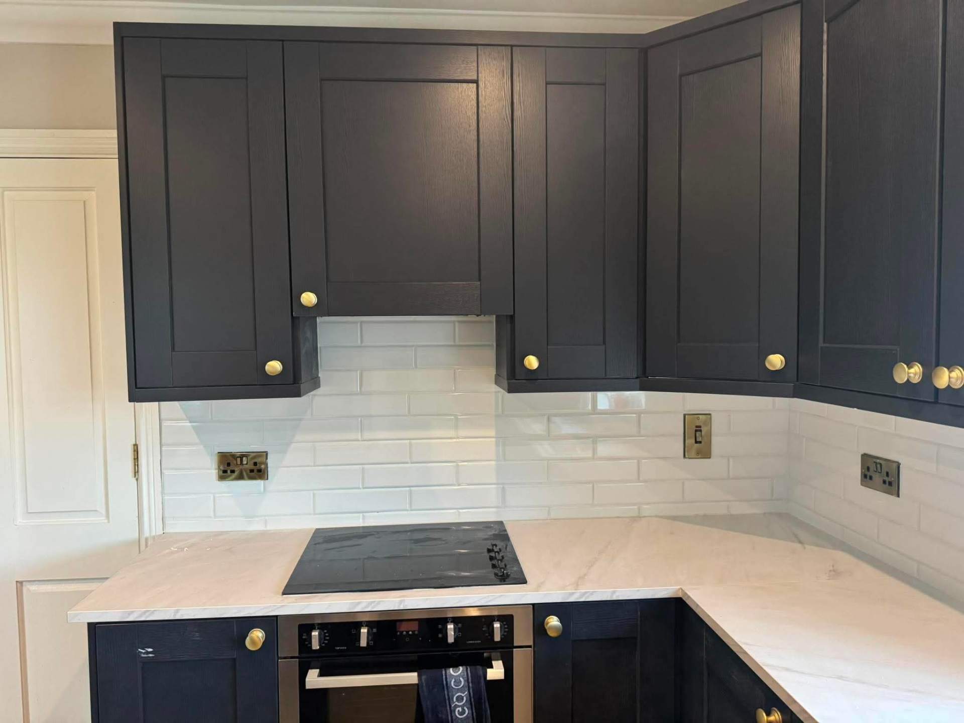 Navy shaker kitchen with bevelled white metro tile splashback